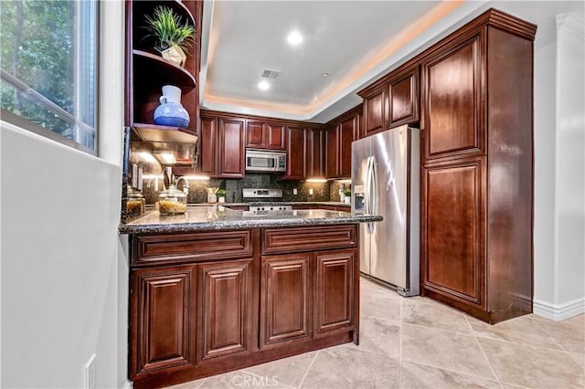 kitchen with decorative backsplash, stainless steel appliances, dark stone counters, and light tile patterned flooring