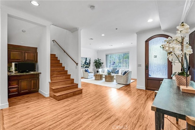 foyer entrance with light wood-type flooring and crown molding