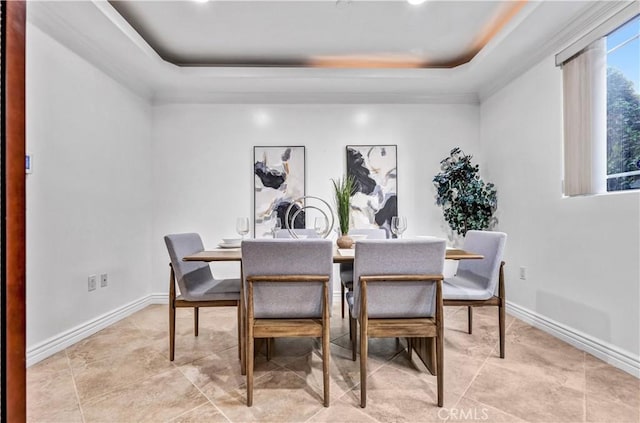 dining area with a tray ceiling and ornamental molding