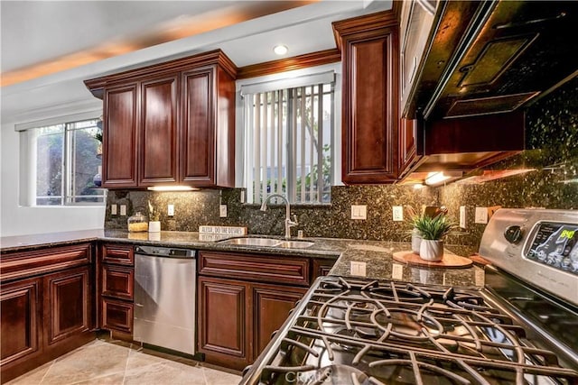 kitchen featuring appliances with stainless steel finishes, dark stone countertops, tasteful backsplash, sink, and light tile patterned flooring