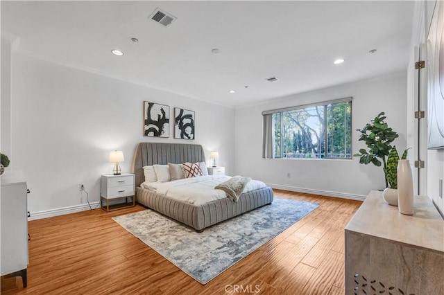 bedroom featuring crown molding and light hardwood / wood-style floors