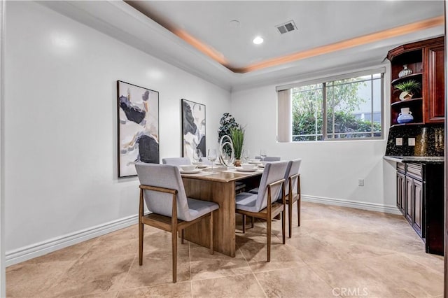 dining room with a raised ceiling