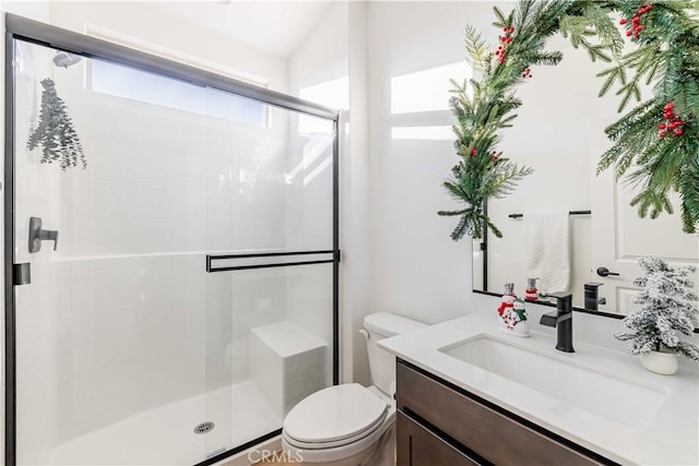 bathroom with an enclosed shower, vanity, and toilet