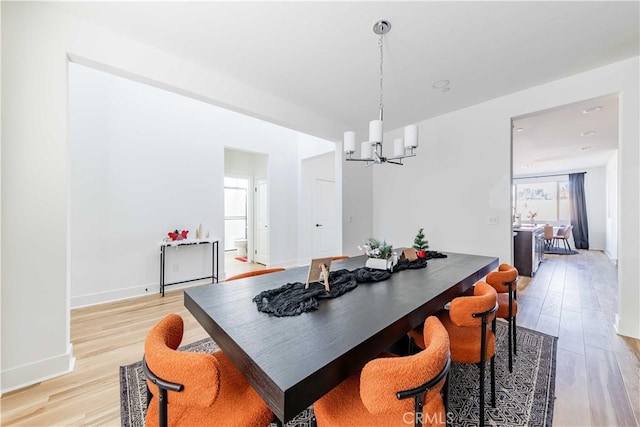 dining room featuring light hardwood / wood-style flooring and a notable chandelier