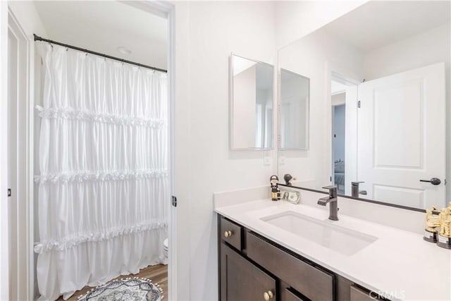 bathroom with toilet, wood-type flooring, and vanity