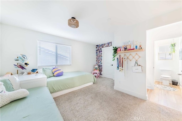 bedroom with ensuite bath and carpet flooring