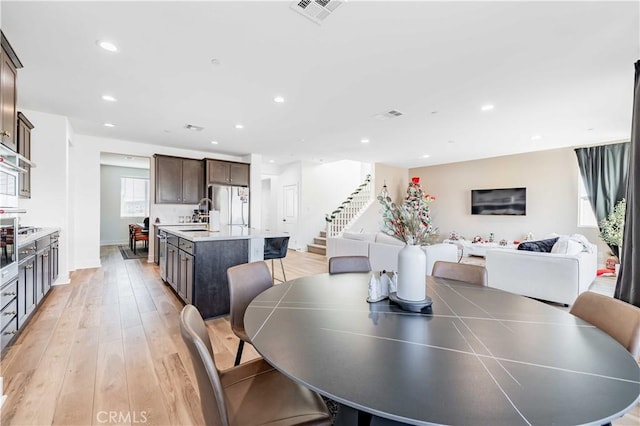 dining room with sink and light wood-type flooring