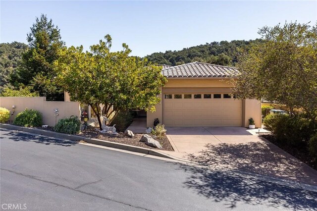 view of front of house with driveway, an attached garage, and stucco siding