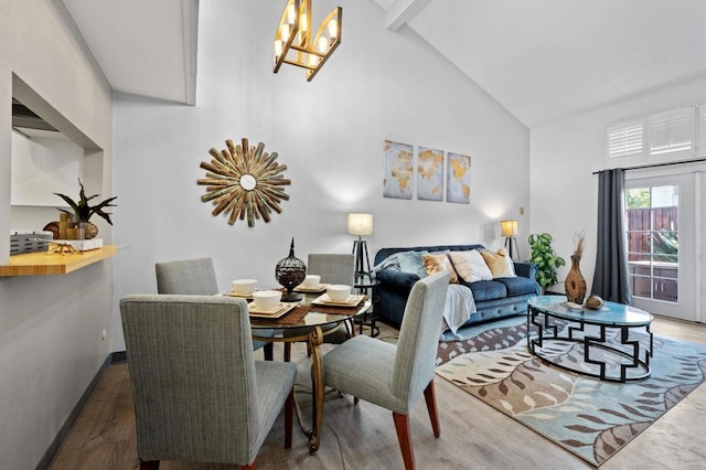 interior space featuring high vaulted ceiling, dark hardwood / wood-style flooring, and a chandelier