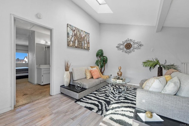 living room with light hardwood / wood-style flooring and lofted ceiling with skylight