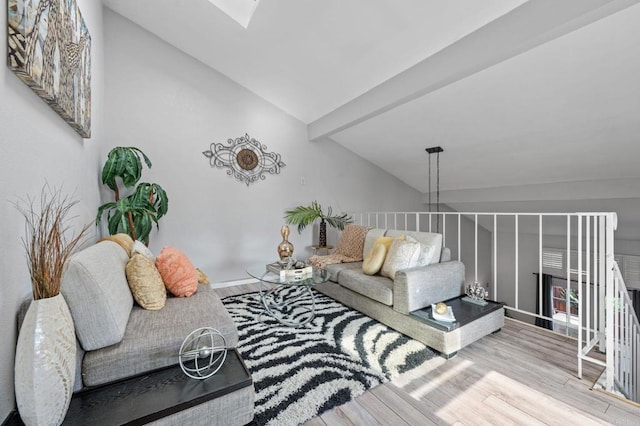 living room with vaulted ceiling with skylight and light hardwood / wood-style floors