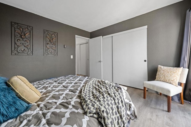 bedroom with a closet and light hardwood / wood-style floors