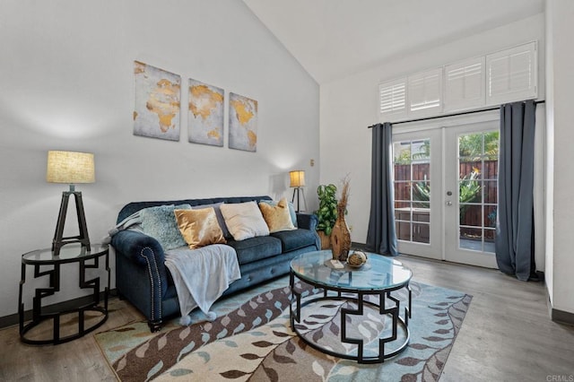 living room with wood-type flooring, french doors, and high vaulted ceiling