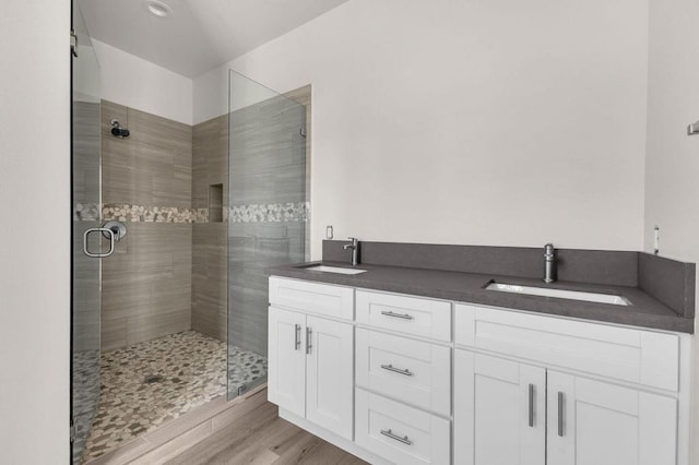 bathroom featuring walk in shower, hardwood / wood-style floors, and vanity