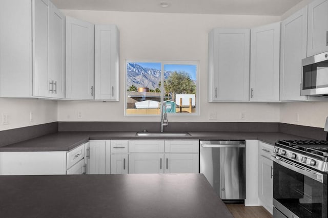 kitchen featuring sink, white cabinets, appliances with stainless steel finishes, and dark hardwood / wood-style floors