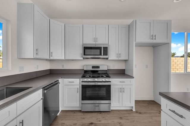 kitchen featuring white cabinets, appliances with stainless steel finishes, and light hardwood / wood-style flooring