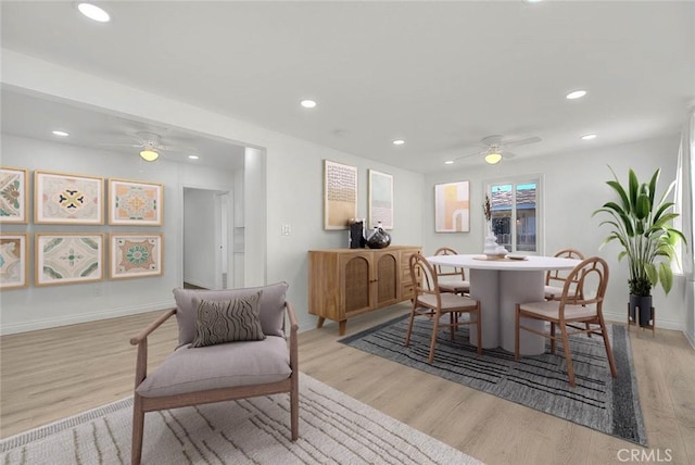 dining space with ceiling fan and light wood-type flooring