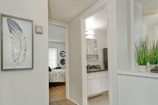 corridor featuring light wood-type flooring and sink