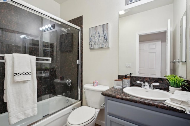 full bathroom featuring toilet, combined bath / shower with glass door, and vanity