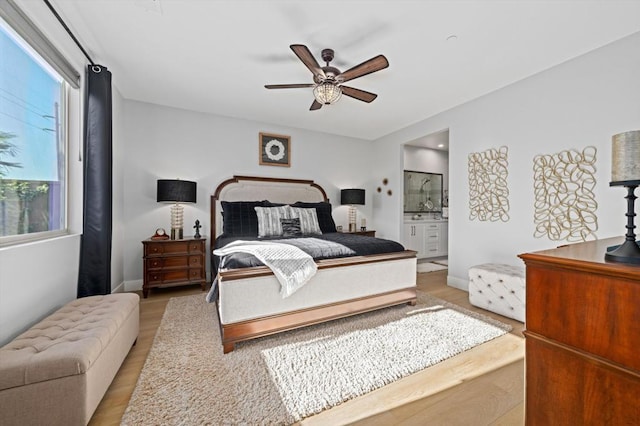 bedroom featuring ceiling fan, connected bathroom, and light hardwood / wood-style floors