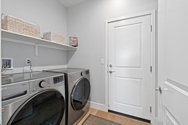 clothes washing area featuring washer and dryer and light hardwood / wood-style flooring