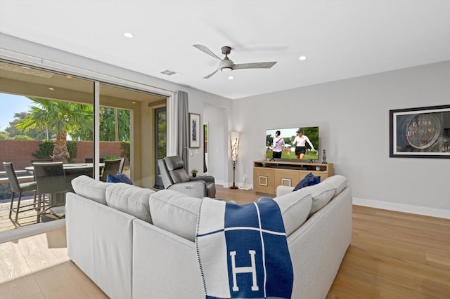 living room with light hardwood / wood-style floors and ceiling fan