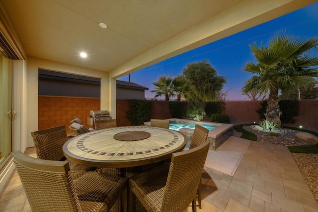 patio terrace at dusk featuring a grill