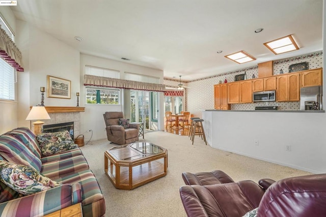 carpeted living room featuring a healthy amount of sunlight and a fireplace