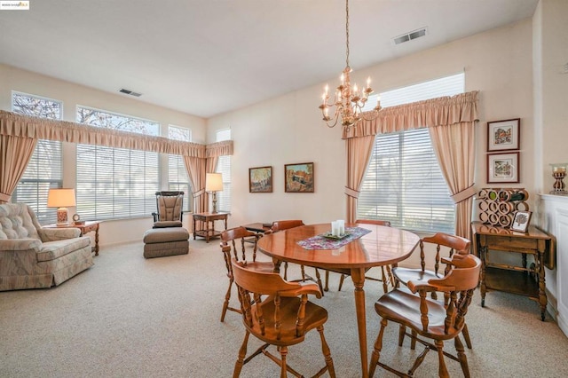 dining room featuring carpet floors and a chandelier