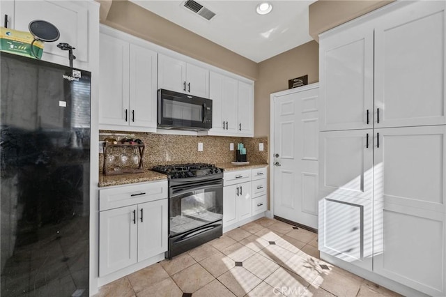 kitchen with black appliances, white cabinets, light stone countertops, and tasteful backsplash