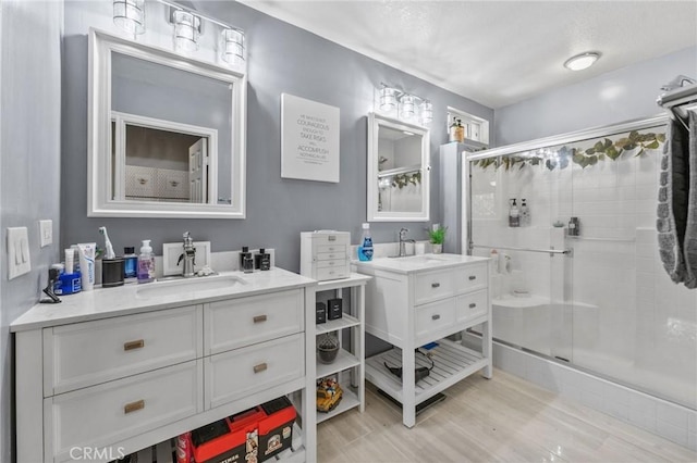 bathroom featuring a shower with shower door, hardwood / wood-style flooring, and vanity