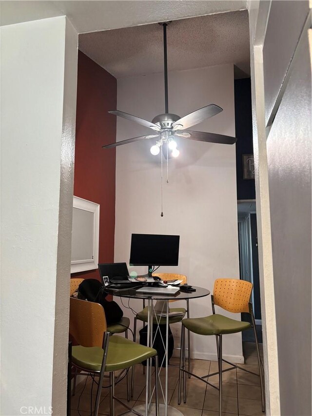 tiled dining space with ceiling fan