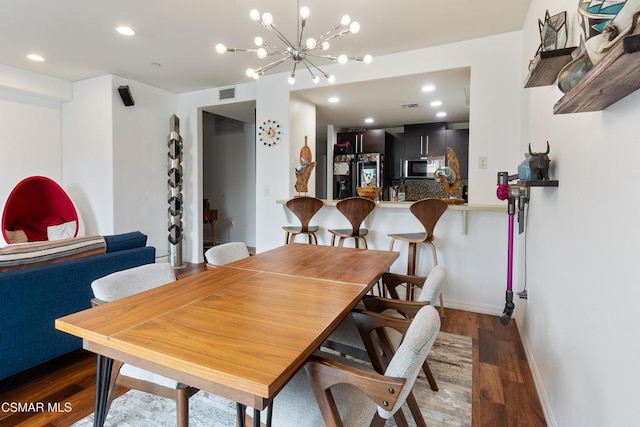 dining area with dark wood-type flooring and a chandelier