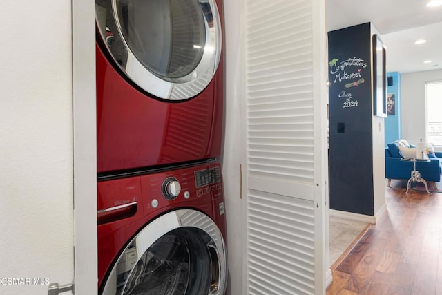 laundry area with stacked washer and dryer and wood-type flooring