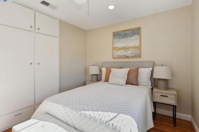 bedroom with hardwood / wood-style flooring, ceiling fan, and a closet