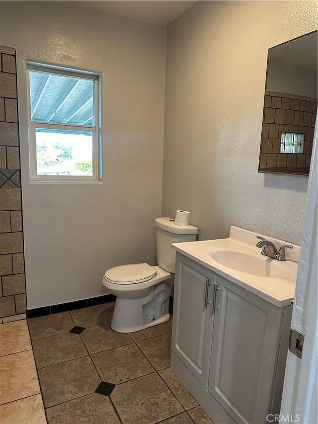 bathroom featuring tile patterned flooring, vanity, and toilet