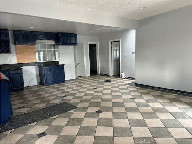 kitchen with a textured ceiling and blue cabinets