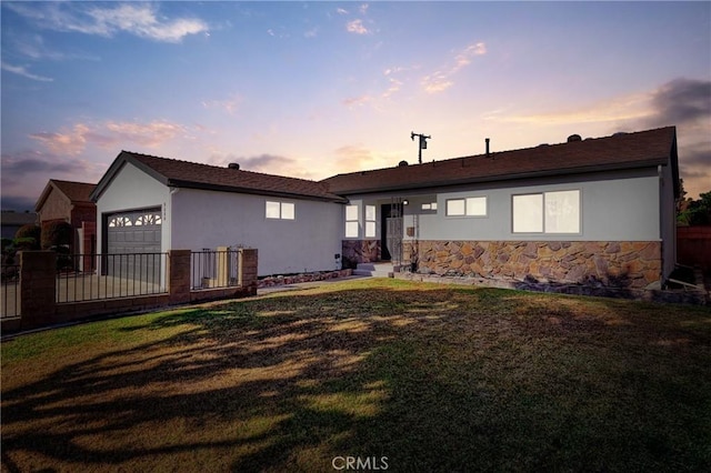 view of front of property featuring a garage and a lawn