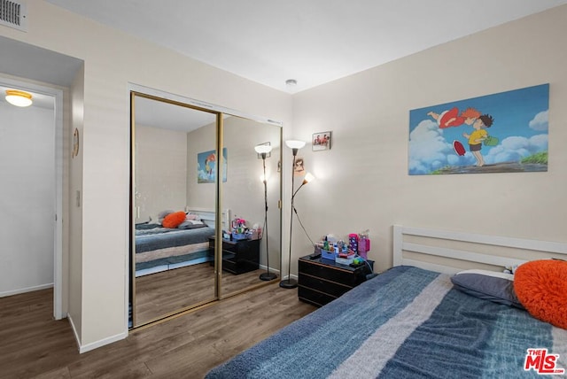 bedroom with hardwood / wood-style floors and a closet