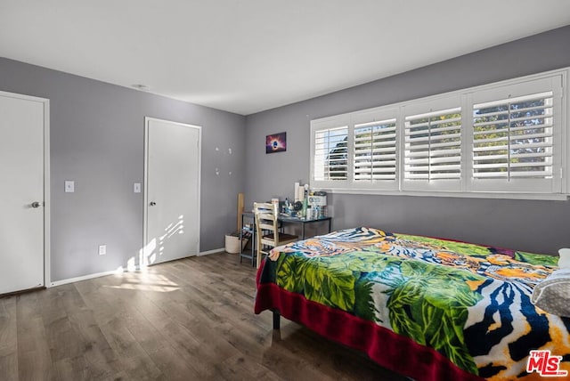 bedroom with dark hardwood / wood-style floors