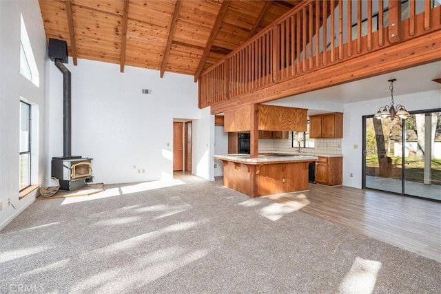 kitchen with wood ceiling, decorative backsplash, a wood stove, high vaulted ceiling, and beamed ceiling