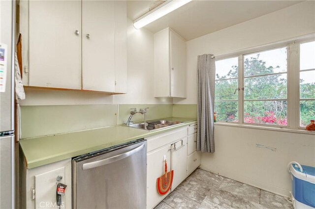 kitchen featuring stainless steel dishwasher, white cabinets, and sink