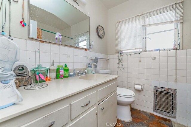 bathroom featuring tile walls, toilet, heating unit, and vanity