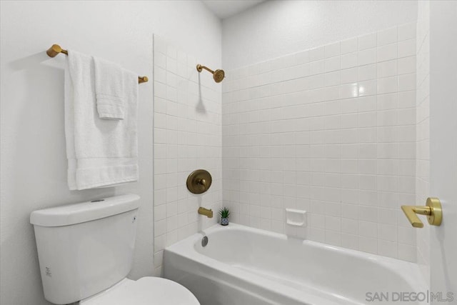 bathroom with toilet and tiled shower / bath