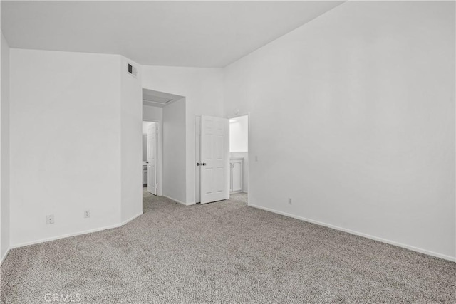 carpeted spare room with lofted ceiling