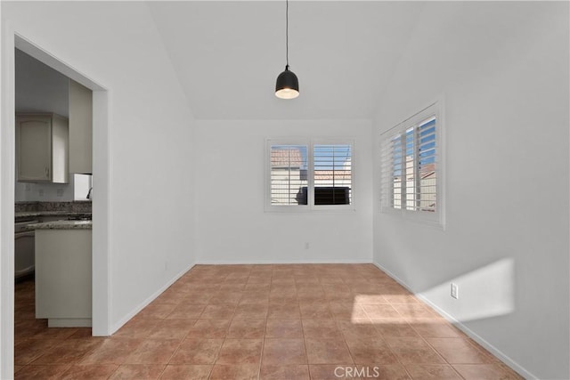 unfurnished dining area with light tile patterned floors and lofted ceiling