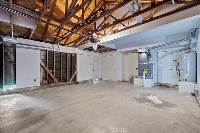 garage with heating unit, a garage door opener, and secured water heater