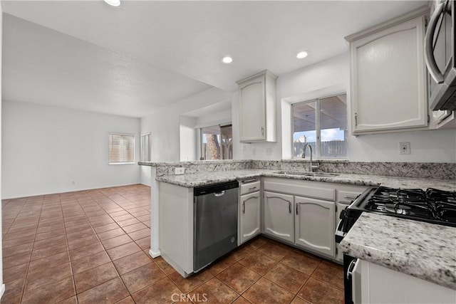 kitchen with a wealth of natural light, stainless steel dishwasher, white cabinets, and sink