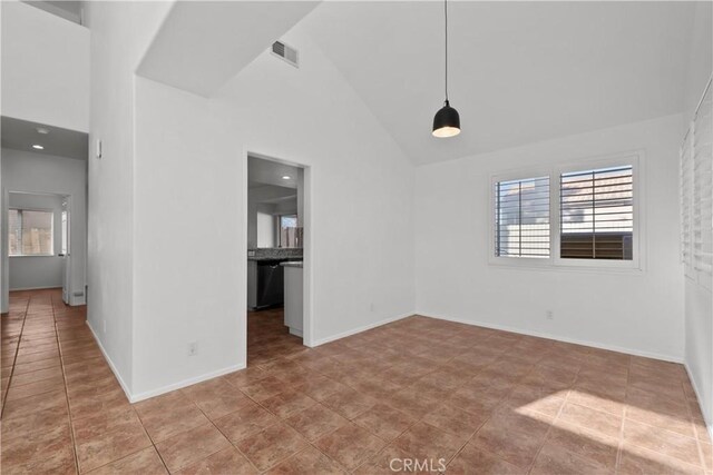 spare room with high vaulted ceiling and light tile patterned floors