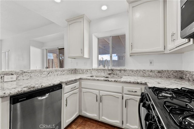 kitchen featuring a wealth of natural light, appliances with stainless steel finishes, white cabinetry, and sink